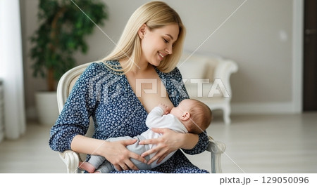 young woman breastfeeding her baby 129050096