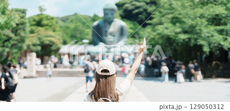 Woman tourist Visiting in Kamakura, Kanagawa prefecture , Japan. happy Traveler sightseeing the Great Buddha statue. Landmark and popular for tourists attraction near Tokyo. Travel and Vacation 129050312
