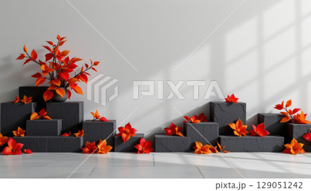 Dark blocks with vibrant orange leaves create warm and artistic display under soft natural light in minimalist setting 129051242