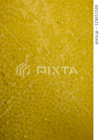 ripe yellow citrus covered with drops of water, wet citrus peel with lots of drops of pure water, closeup 129051589