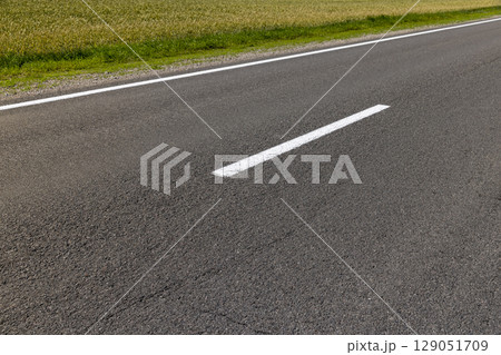 road during the day in sunny weather, road for vehicles with white road markings, closeup 129051709