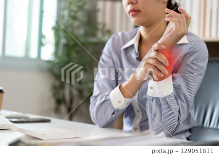 Office Syndrome: Woman Holding Her Wrist in Pain While Working Office Syndrome: Woman Holding Her Wrist in Pain While Working 129051811