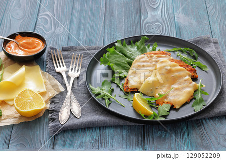 grilled chicken breast topped with melted cheese 129052209