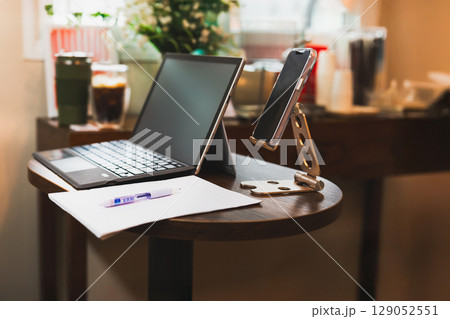 Business technology and statistics concept smartphone, laptop computer with pen and paper on table. Business technology and statistics concept smartphone, laptop computer with pen and paper on table. 129052551