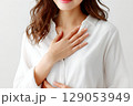 白いシャツを着て胸に手を当て、安心する若い女性 129053949