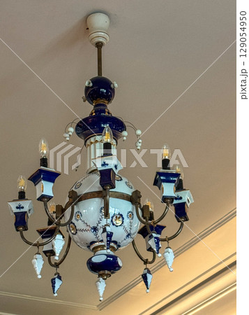 Elegant antique chandelier with blue accents in a vintage interior 129054950