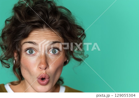 Close-up of natural, curly dark brown hair against a teal background. 129055304