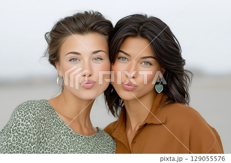 Close-up of two women standing closely together, showcasing their friendship and connection. 129055576