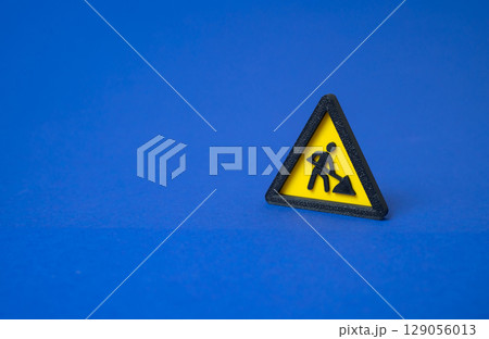 Sign men at work. Repairs and restoration work. Under construction. Road maintenance underway. Infrastructure upgrade ongoing. Temporary disruption expected. Utility servicing. 129056013