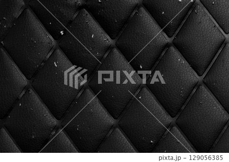 Scratched black leather material with rhombic geometric pattern. Damaged surface. Abstract dark textured background Scratched black leather material with rhombic geometric pattern. Damaged surface. Abstract dark textured background 129056385