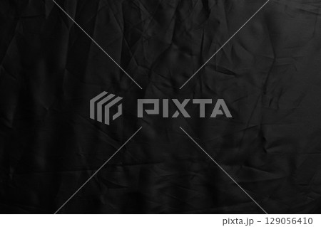 Black crumpled material surface of dark synthetic fabric. Abstract wrinkled background Black crumpled material surface of dark synthetic fabric. Abstract wrinkled background 129056410