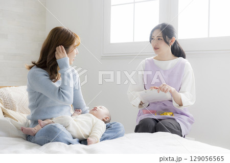 保健師に相談する若い母親 129056565