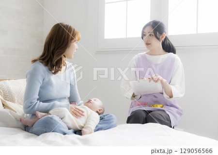 保健師に相談する若い母親 129056566