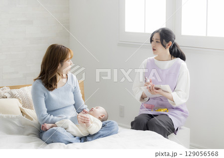 保健師に相談する若い母親 129056568