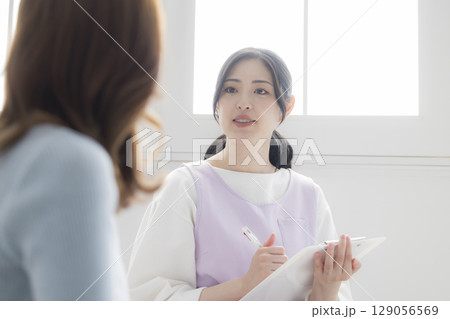 保健師に相談する若い母親 保健師に相談する若い母親 129056569