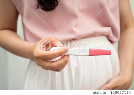 Asian holding pregnancy test for female of ovulation day, fetus, maternity, childbirth, birth control. Asian holding pregnancy test for female of ovulation day, fetus, maternity, childbirth, birth control. 129057110