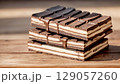 Stack of Premium Milk and Dark Chocolate Bars on Rustic Wooden Background 129057260