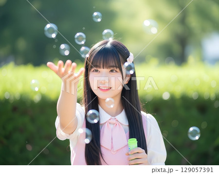 公園でシャボン玉で遊ぶ女子高生 129057391