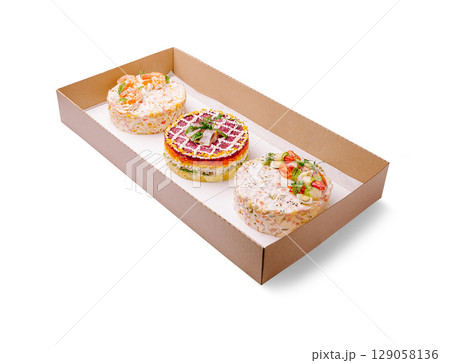 An elegant catering box featuring three beautifully styled layered salads shaped like cakes An elegant catering box featuring three beautifully styled layered salads shaped like cakes 129058136