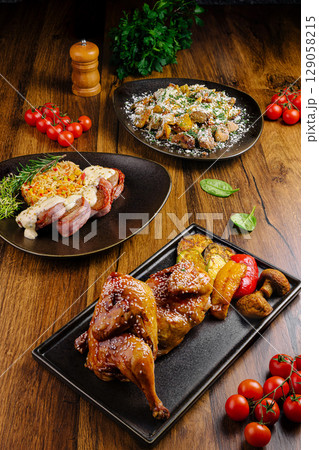 Delicious gourmet dishes arranged on a wooden table with vibrant ingredients 129058215