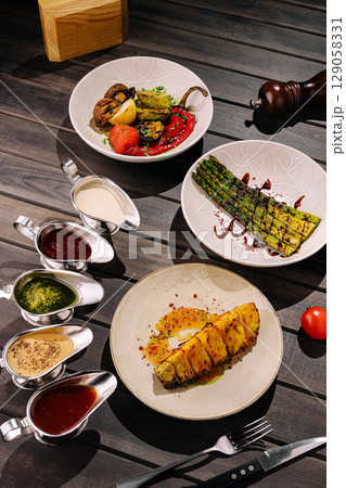 Colorful vegetarian platter served on wooden table with delicious sauces 129058331