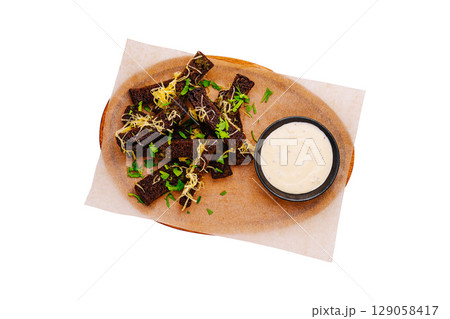 Delicious bread sticks served with creamy dip on rustic wooden platter 129058417