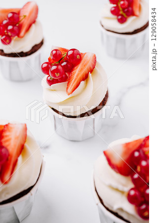 Fresh strawberry and red currant cupcakes in a vibrant setting 129058434