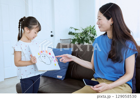 子どもが描いた絵を母親に見せる微笑ましい親 129058530