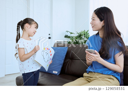 子どもが描いた絵を母親に見せる微笑ましい親 129058531