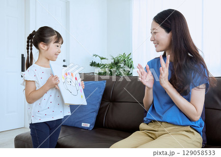 子どもが描いた絵を母親に見せる微笑ましい親 129058533