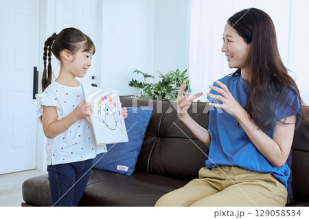 子どもが描いた絵を母親に見せる微笑ましい親 129058534