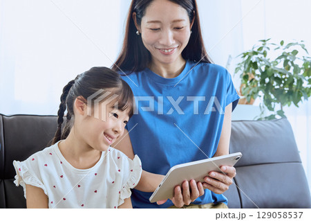 親子でタブレットを見るデジタル学習のひとと 129058537