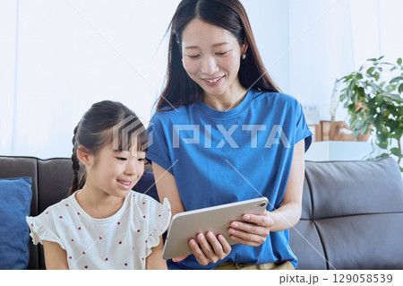 親子でタブレットを見るデジタル学習のひとと 親子でタブレットを見るデジタル学習のひとと 129058539
