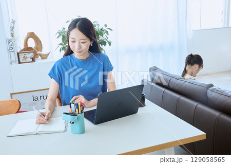 在宅勤務する母親とタブレットを楽しむ子ども 129058565