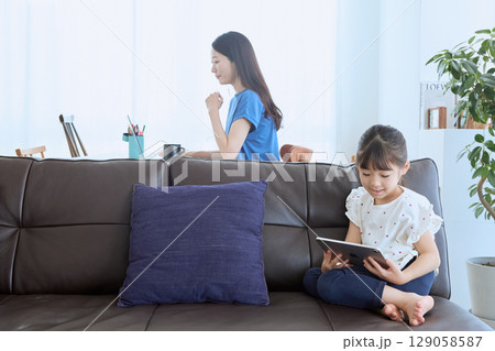 在宅勤務する母親とタブレットを楽しむ子ども 129058587