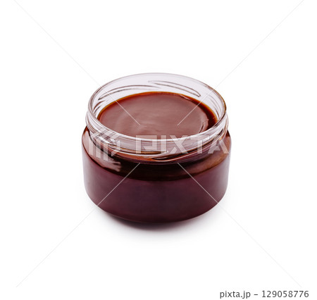 Chocolate sauce in a glass jar on a white background for dessert Chocolate sauce in a glass jar on a white background for dessert 129058776