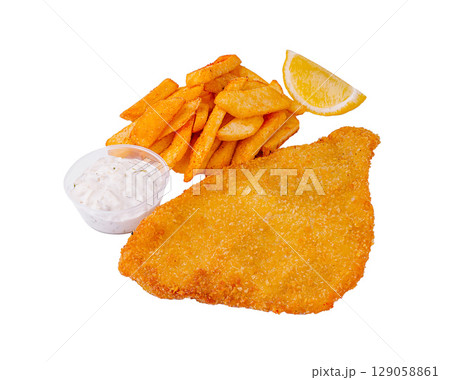 Crispy fried schnitzel with golden fries and tartar sauce served with lemon 129058861