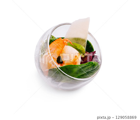 Delightful shrimp salad served in a glass bowl with fresh greens 129058869
