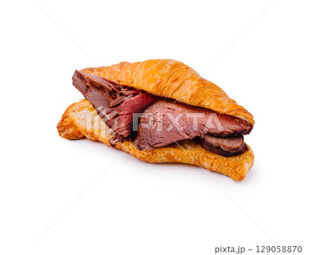 Delicious croissant sandwich filled with tender roast beef 129058870