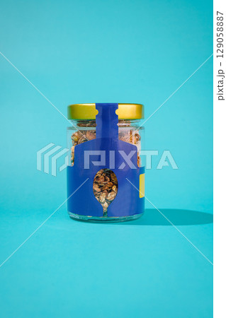 Creative packaging for a glass jar filled with granola on a bright background Creative packaging for a glass jar filled with granola on a bright background 129058887