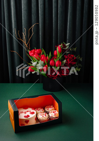 Celebration cake and cupcakes with flowers arranged for special occasion 129058982
