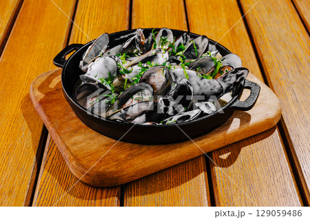 Delicious fresh seafood dish served in a skillet on wooden table 129059486