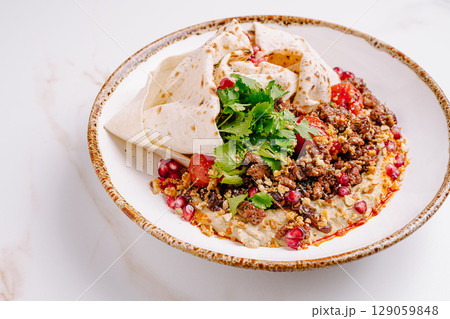 Delicious dish featuring seasoned meat, fresh ingredients, and herbs Delicious dish featuring seasoned meat, fresh ingredients, and herbs 129059848