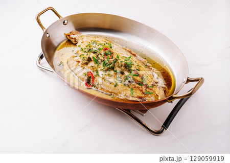Deliciously cooked whole fish garnished with fresh herbs and spices Deliciously cooked whole fish garnished with fresh herbs and spices 129059919