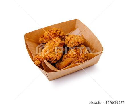 Crispy fried chicken wings served in a brown paper container 129059972
