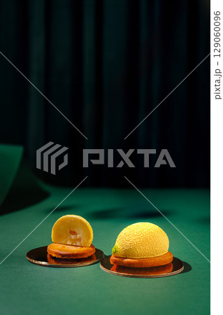 Creative dessert showcasing a lemon-inspired design on a green table Creative dessert showcasing a lemon-inspired design on a green table 129060096
