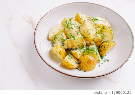 Freshly prepared boiled potatoes garnished with dill served in a bowl 129060123