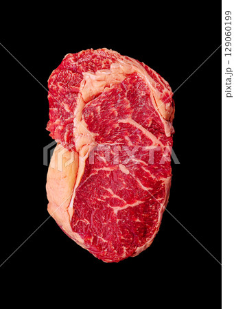 Prime cut of ribeye steak displayed against a black background Prime cut of ribeye steak displayed against a black background 129060199