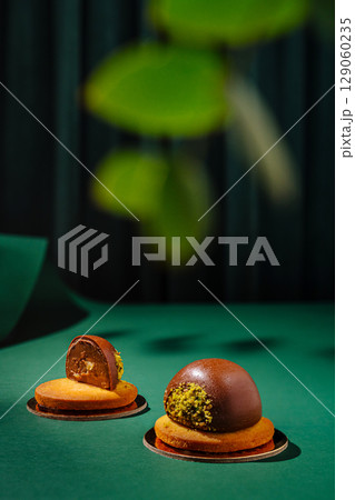 Delicious dessert duo showcases chocolate and pistachio treats on green backdrop 129060235