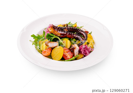 Octopus salad with vegetables served on a white plate at a restaurant 129060271